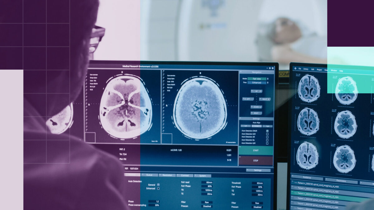 A professional at a desk with screens that show brain scans.